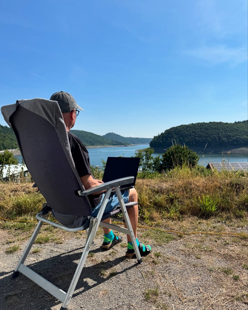 Kriminal-Roman Autor Jörg Manz auf einem Campingsessel mit Blick über den Edersee