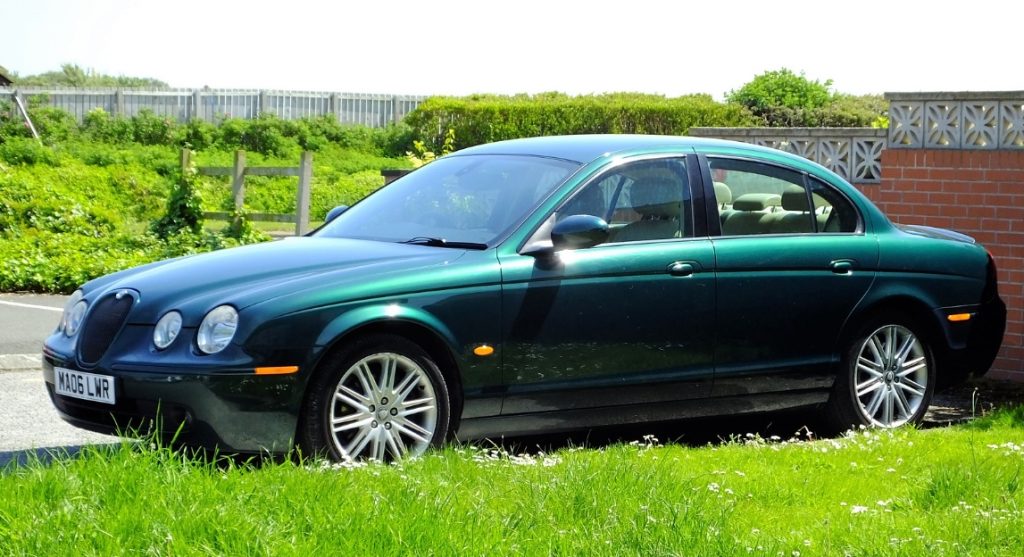 Bildschirm Foto aus dem Internet mit einem britisch grünen Jaguar S-Type vor einer Garage stehend